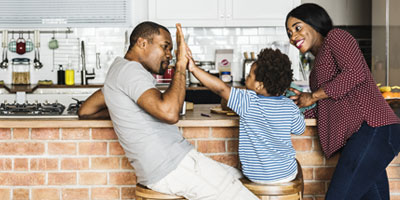 Happy Family High-Fiving in Home